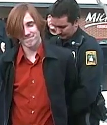 Andrew Carroll being arrested for holding a bud of marijuana.